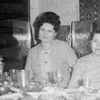 Four people seated at a set dining table.